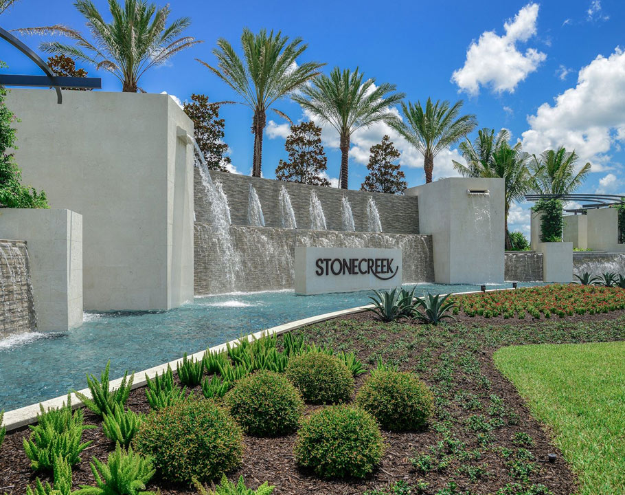 Entrance sign and fountains against a background of Palm Tress for Stonecreek in Naples, Florida